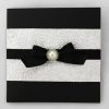 WEDINV126 Black and ivory wedding invitation with embossed paper black ribbon bow and pearl