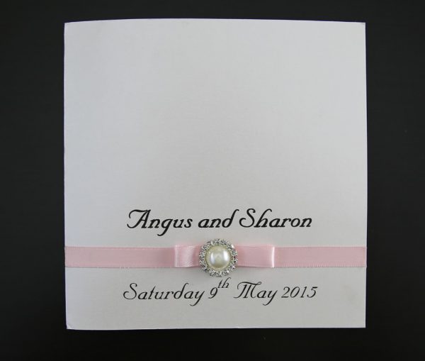 WEDINV01 front of pink ribbon and bow with pearl ivory wedding invitation