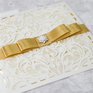 WEDINV151 ivory lasercut wedding invitation with gold ribbon bow and diamante with gold and ivory insert